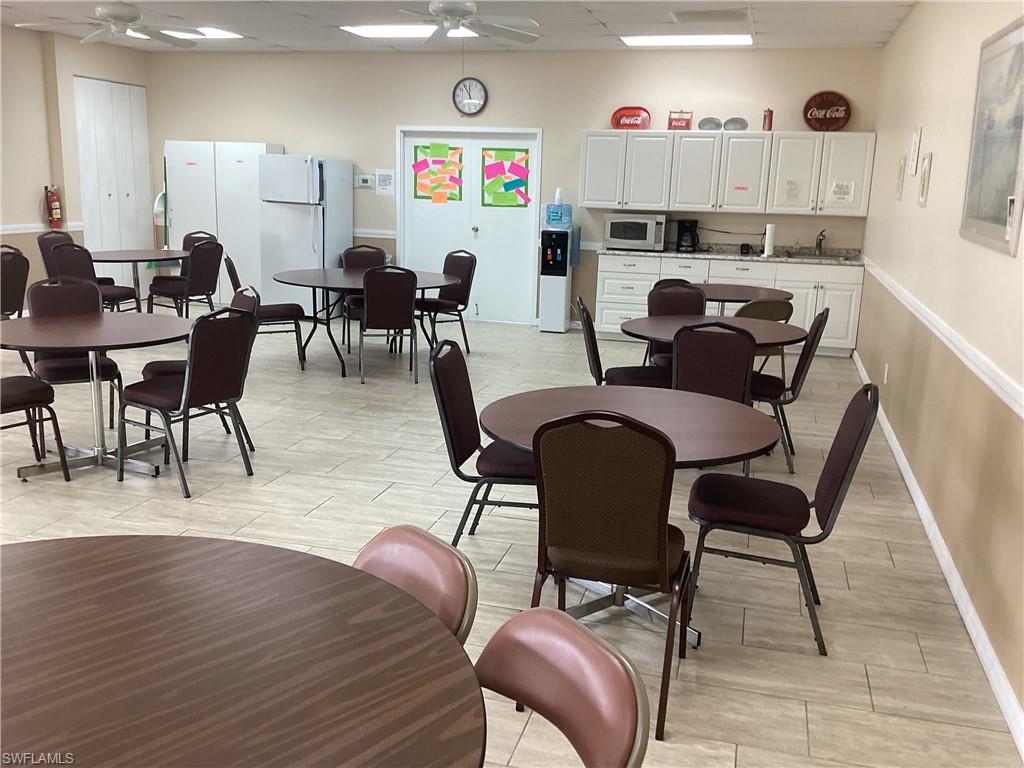 4 Chateau Way Naples, FL 34112 - Photo 36 of 45 a living room with furniture and a dining table with kitchen view