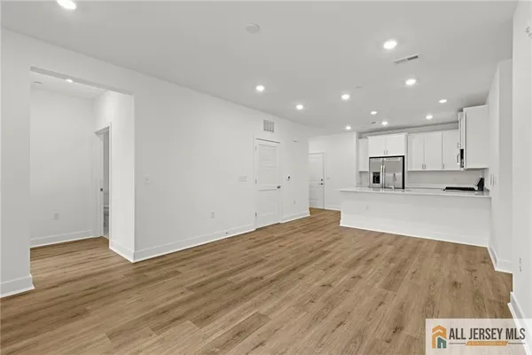 a view of kitchen with kitchen island wooden floor center island and stainless steel appliances