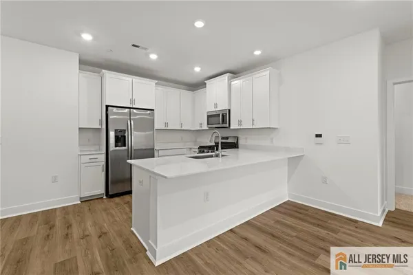 a view of kitchen with refrigerator microwave and stove