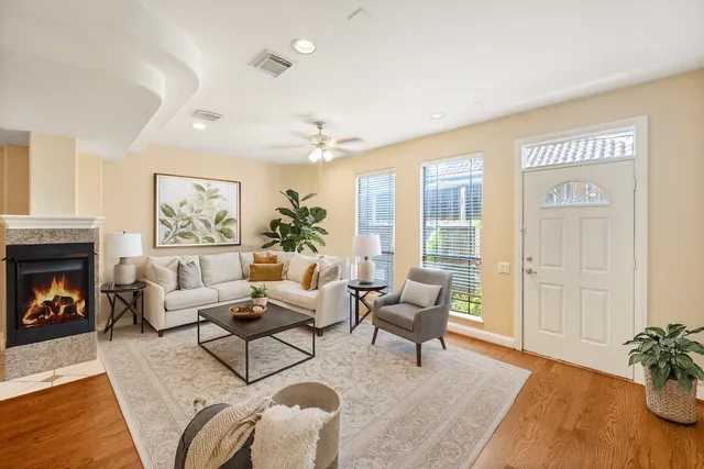 an empty room with wooden floor fireplace and windows