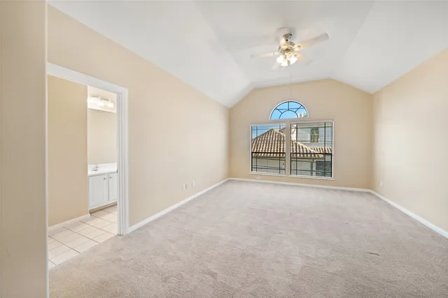 a view of an empty room with a chandelier fan