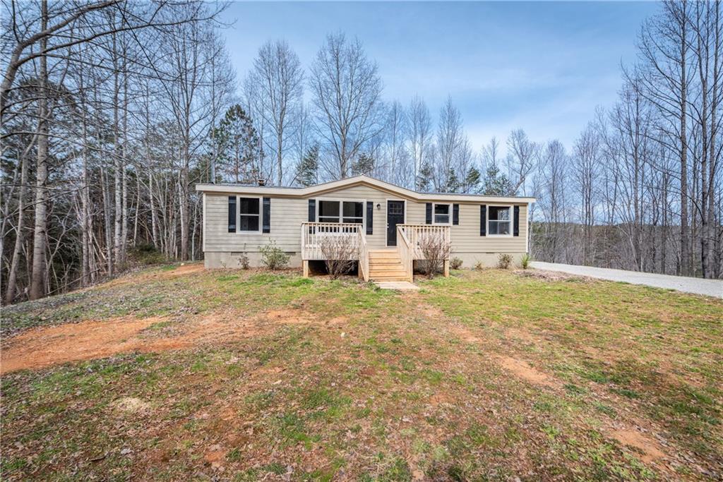 660 Moores Gin Road Fairmount, GA 30139 - Photo 1 of 1 a front view of house with yard and trees in the background