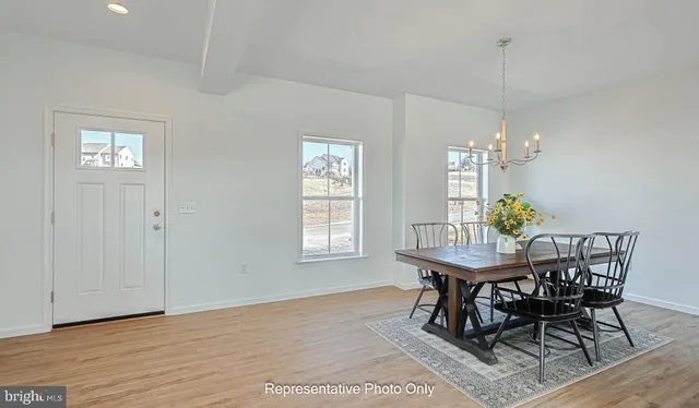 a dining room with chandelier and wooden floor