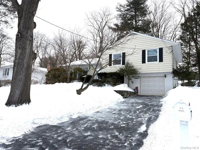 a front view of a house with a yard covered in snow