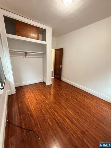 an empty room with wooden floor and closet