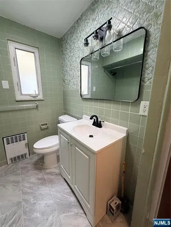 a bathroom with a toilet sink and mirror