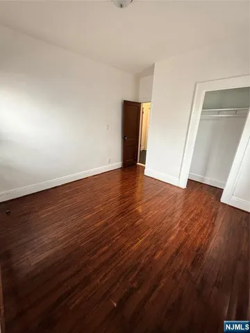 an empty room with wooden floor and closet