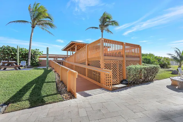 a view of a dining room with furniture a kitchen and chandelier