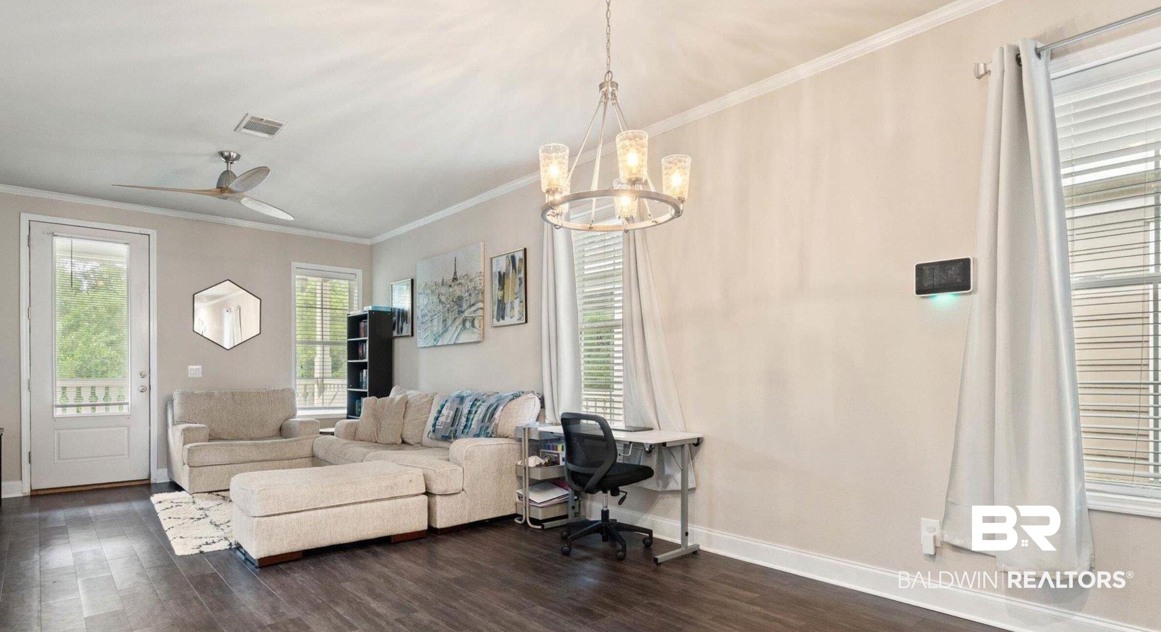 25806 Pollard Road, Unit 203 Daphne, AL 36526 - Photo 3 of 14 Living area featuring crown molding, a ceiling fan, dark wood-style flooring, a chandelier, and a desk