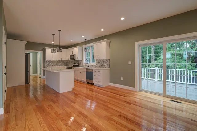 a large kitchen with cabinets and wooden floor