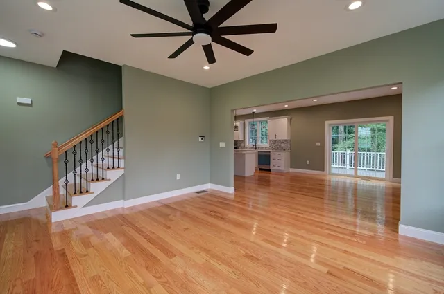 a view of an empty room with window and wooden floor