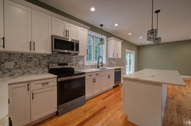 a kitchen with a sink a stove and cabinets