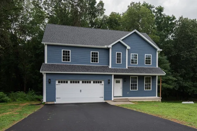 a front view of a house with a garden and yard