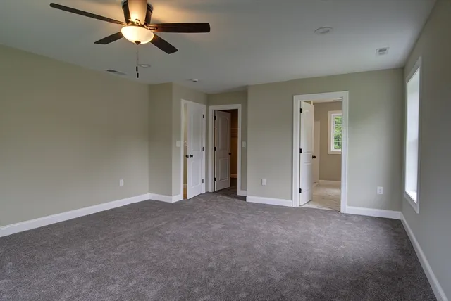 an empty room with closet and a chandelier fan
