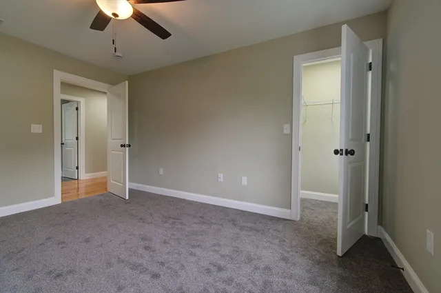 a view of an empty room and chandelier fan
