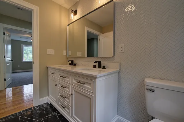 a bathroom with a sink a toilet and mirror