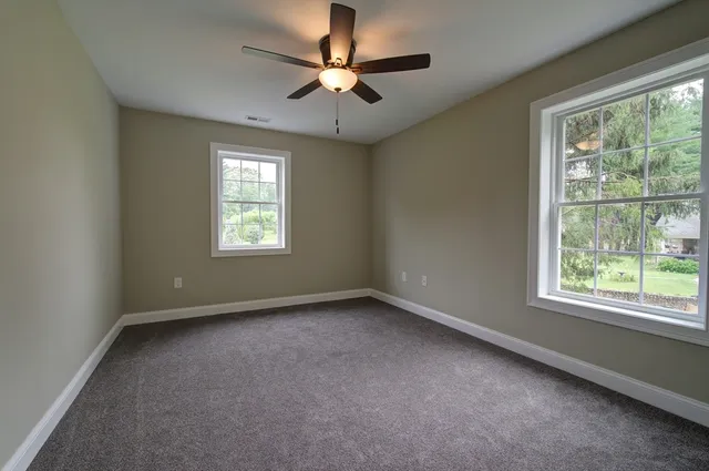 an empty room with a window and a fan
