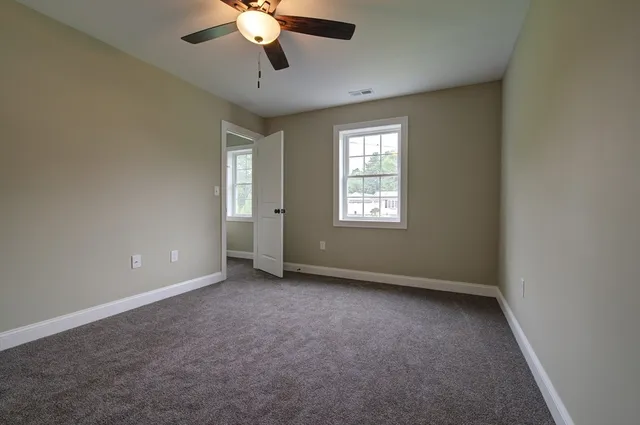an empty room with a window and a fan