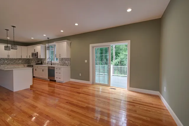 a view of kitchen with granite countertop cabinets and refrigerator