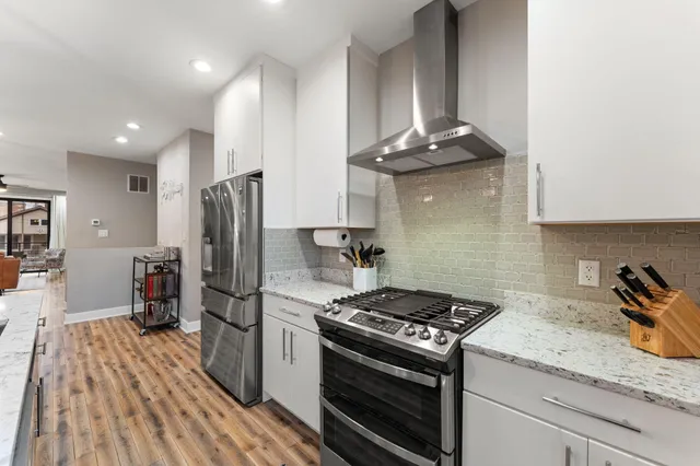 a kitchen with stainless steel appliances granite countertop a stove a refrigerator and a refrigerator