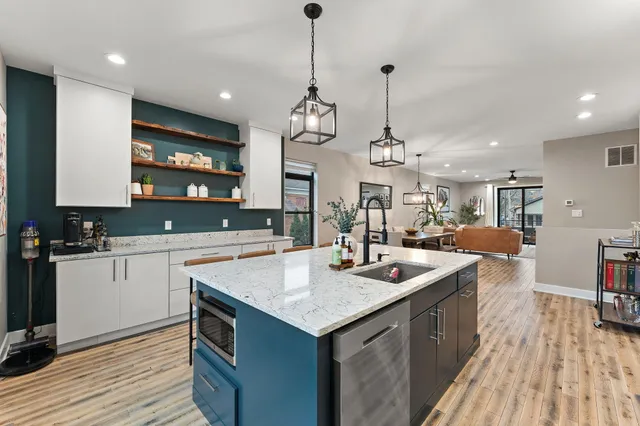 a kitchen with a sink stove and wooden floor