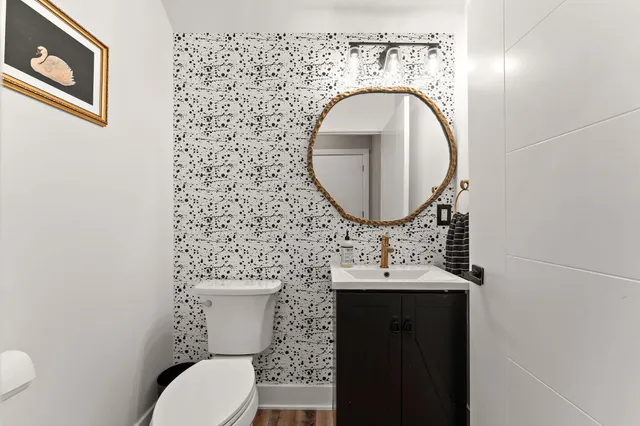 a bathroom with a toilet sink vanity and mirror