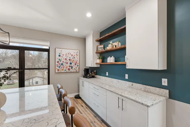 a kitchen with stainless steel appliances granite countertop a sink and a refrigerator