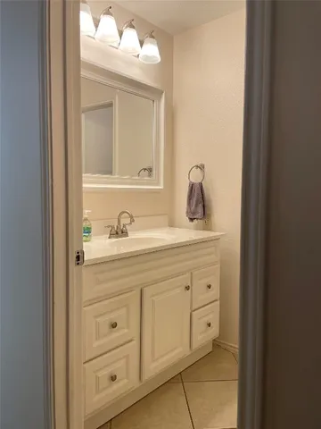 a bathroom with a granite countertop sink vanity and mirror
