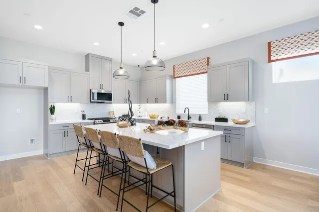 a kitchen with a sink a stove a dining table and chairs