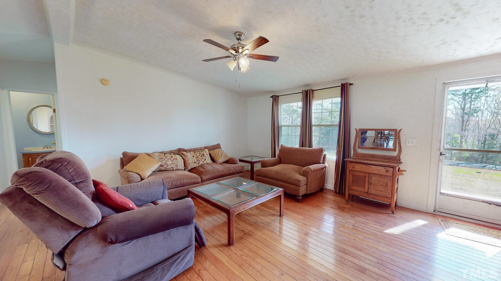 214 Hassel Clayton Road Roxboro, NC 27574 - Photo 12 of 38 a living room with furniture and a wooden floor