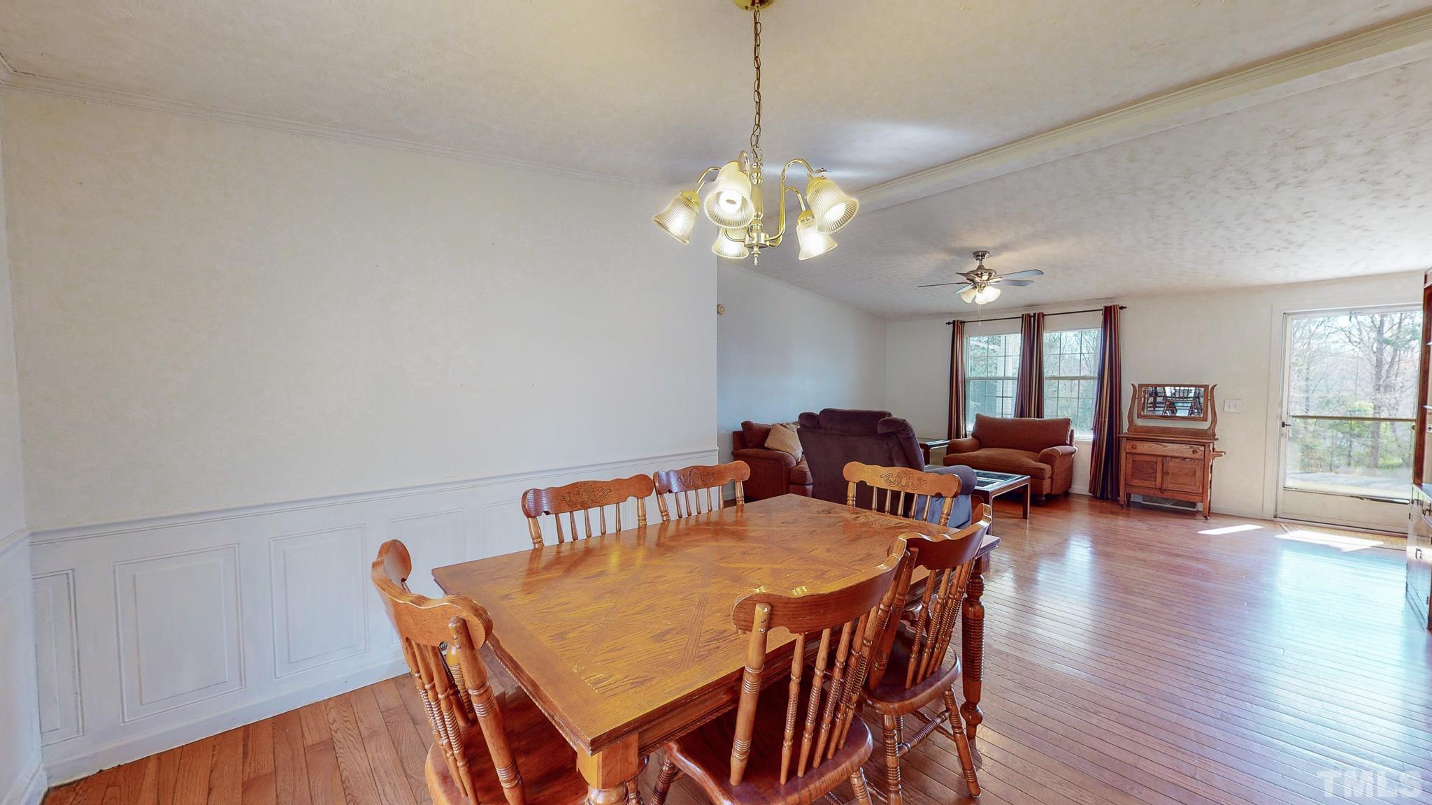 214 Hassel Clayton Road Roxboro, NC 27574 - Photo 21 of 38 a view of a dining room with furniture a chandelier and wooden floor