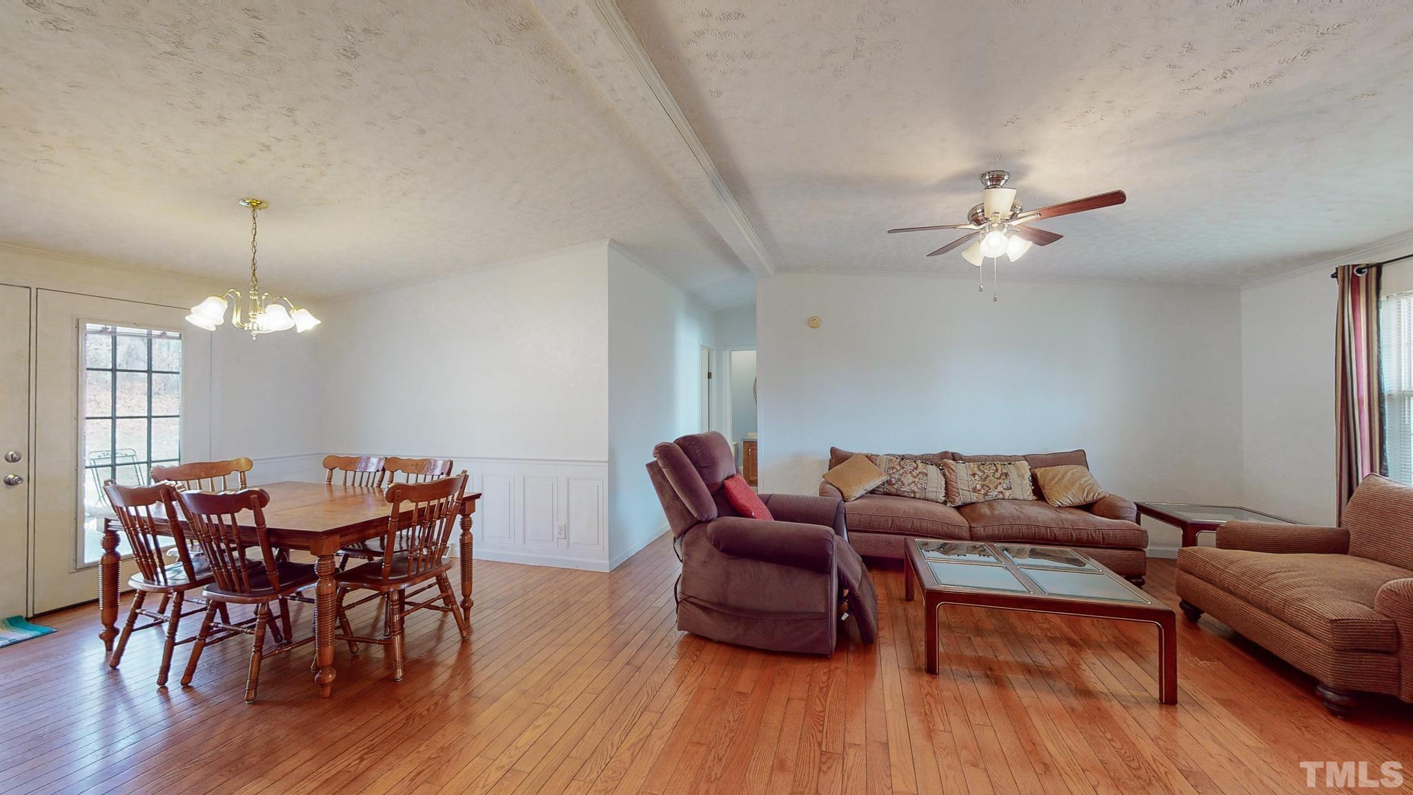 214 Hassel Clayton Road Roxboro, NC 27574 - Photo 25 of 38 a living room with furniture a chandelier and wooden floor