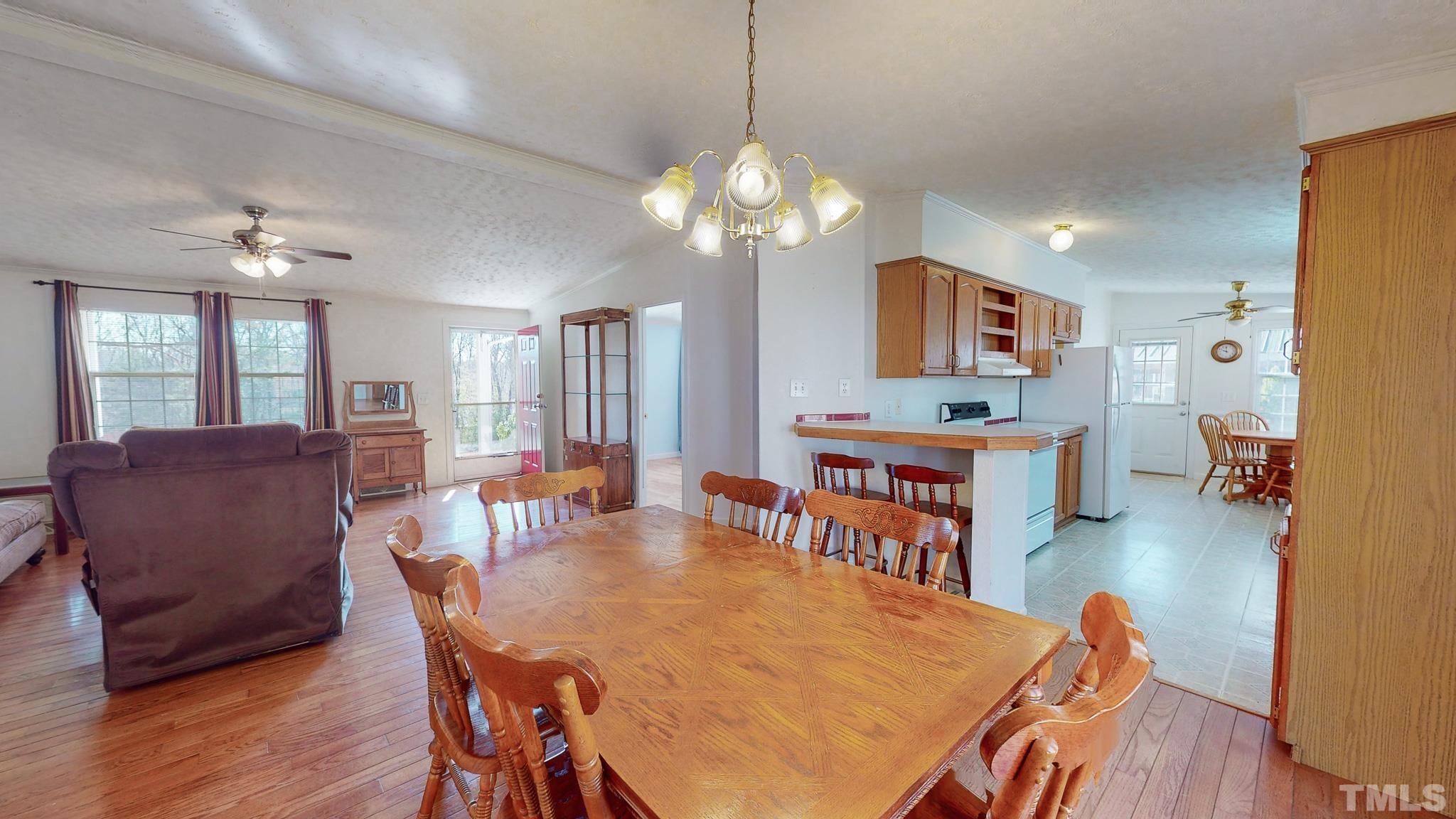 214 Hassel Clayton Road Roxboro, NC 27574 - Photo 3 of 38 a view of a dining room with furniture and wooden floor