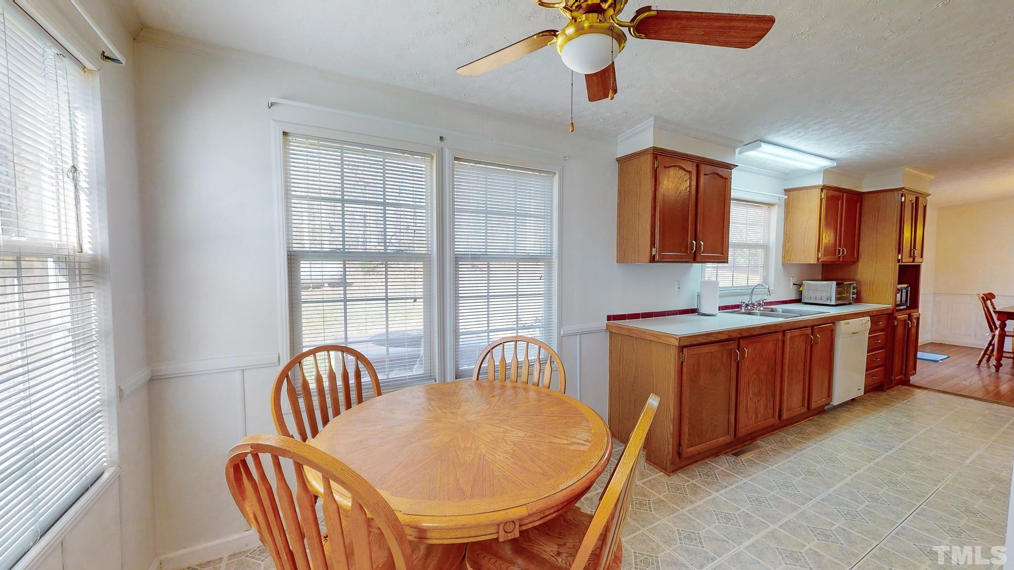 214 Hassel Clayton Road Roxboro, NC 27574 - Photo 5 of 38 a kitchen with stainless steel appliances granite countertop a sink a stove a dining table and chairs