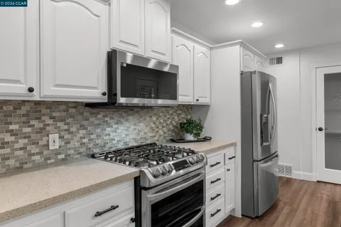 a kitchen that has a sink a stove and wooden floor