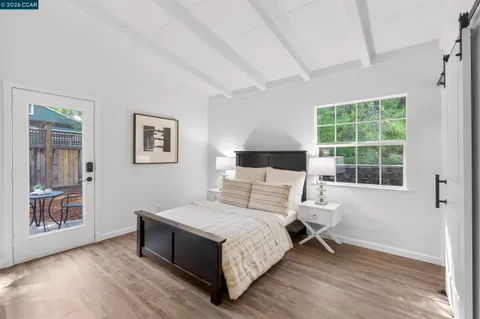 a bedroom with wooden floor and a bed