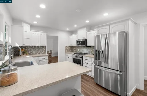 a kitchen with white cabinets and stainless steel appliances