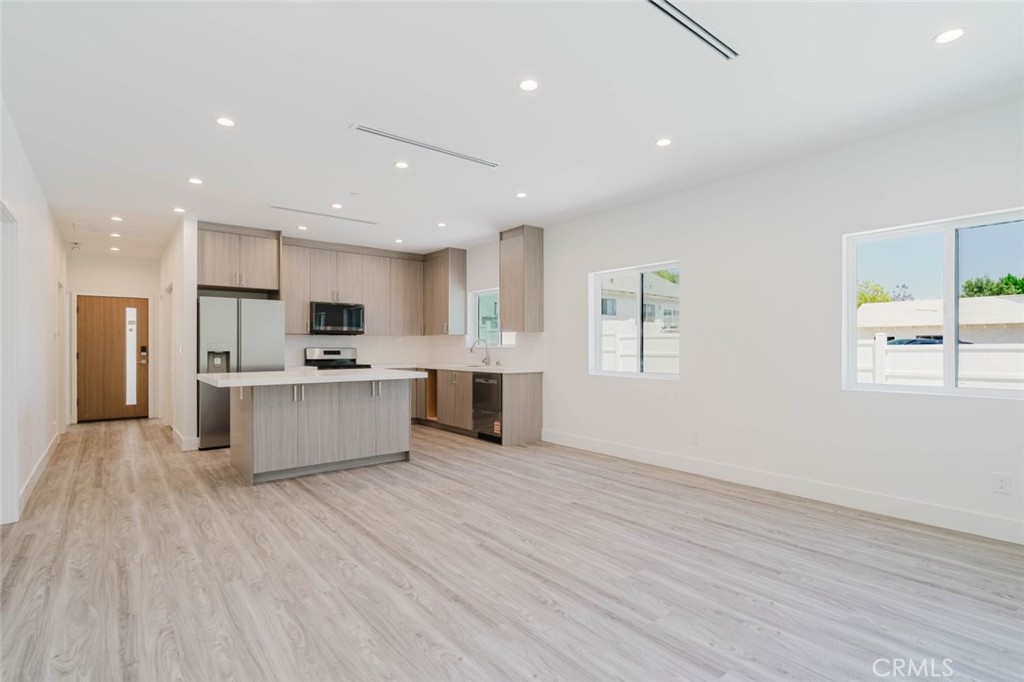17846 Rinaldi Street Granada Hills, CA 91344 - Photo 10 of 34 a large kitchen with stainless steel appliances refrigerator a stove top oven and white cabinets