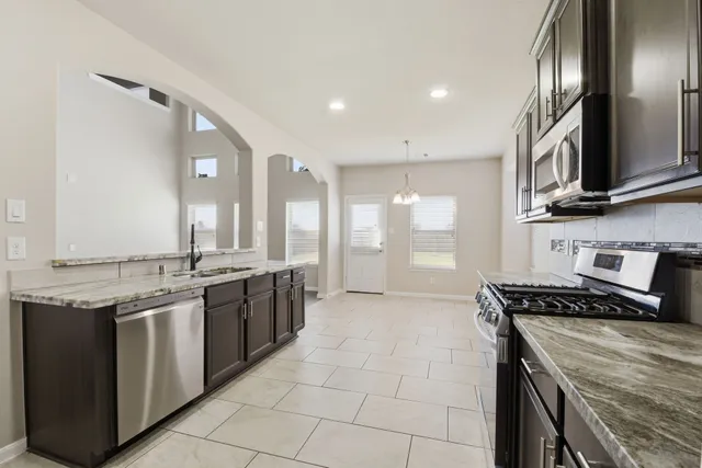 a kitchen with kitchen island granite countertop a stove sink and cabinets