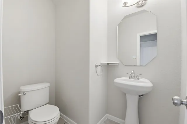 an empty room with chandelier fan and windows