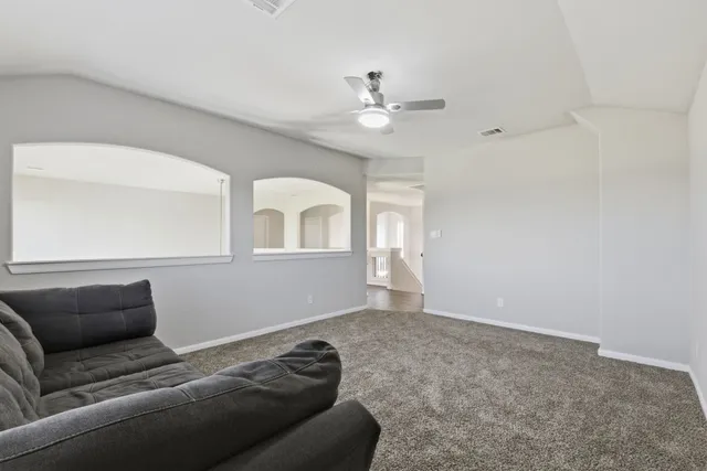 a living room with furniture and a ceiling fan