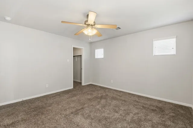 an empty room with a fan and a fan
