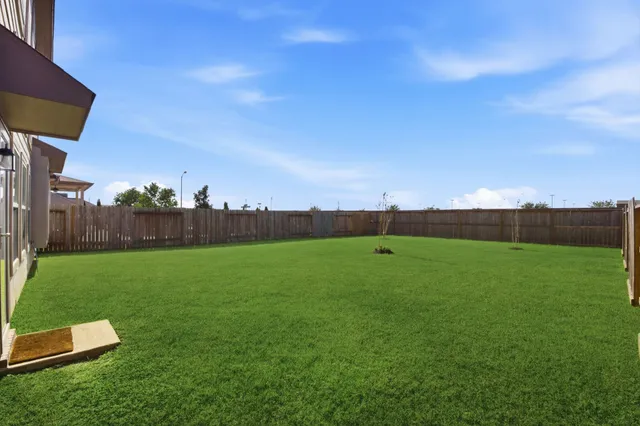a view of a big house with a big yard and large trees