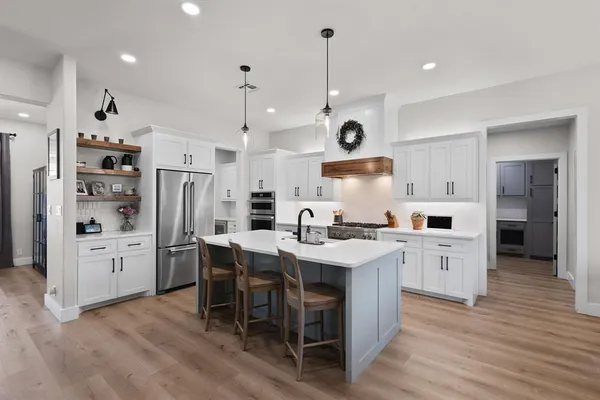 a kitchen with white cabinets and stainless steel appliances