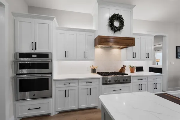 a kitchen with a dining table chairs and white cabinets
