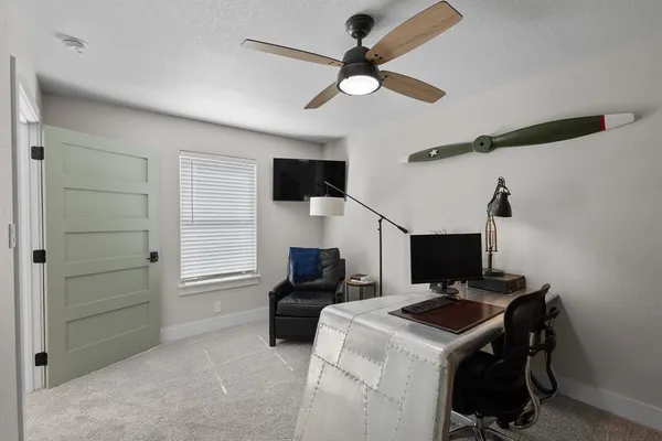 a living room with furniture and a ceiling fan
