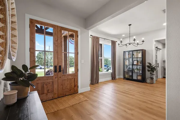a living room with furniture large window and wooden floor