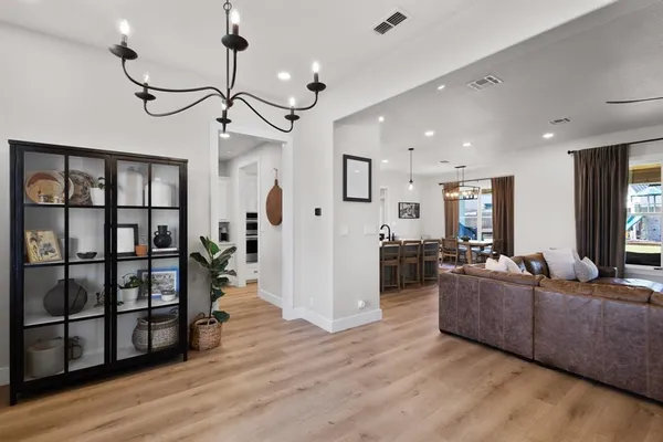 a living room with furniture wooden floor and a chandelier