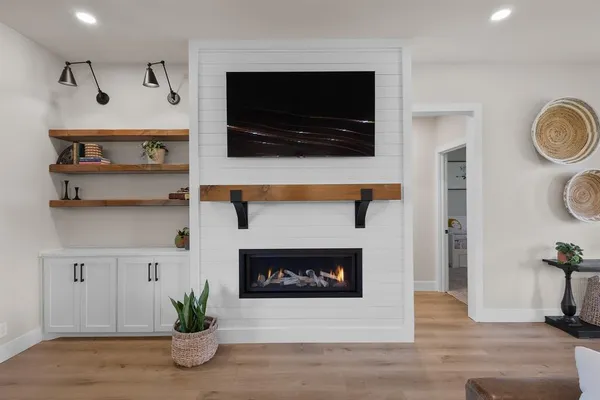 a living room with a fireplace and a flat screen tv
