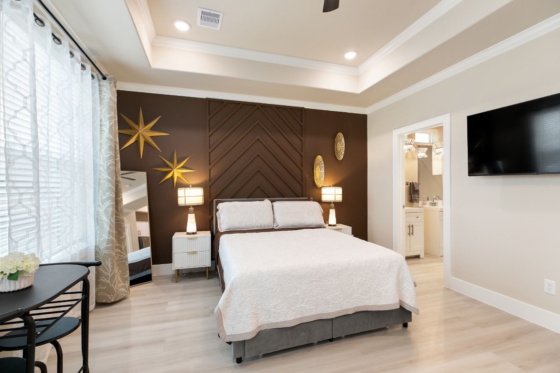 a spacious bedroom with a bed and a flat screen tv